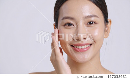 A woman smiling with her hand on her face 127038681