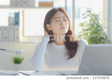 A young woman with a tired expression worried about work in the office 127039976