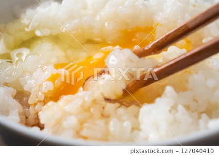 Image of raw egg on rice (stock photo) 127040410