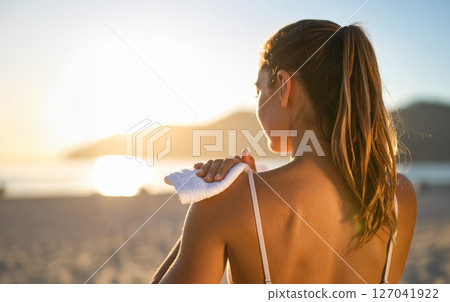 A woman working out on the beach, sweating, beautiful muscles 127041922