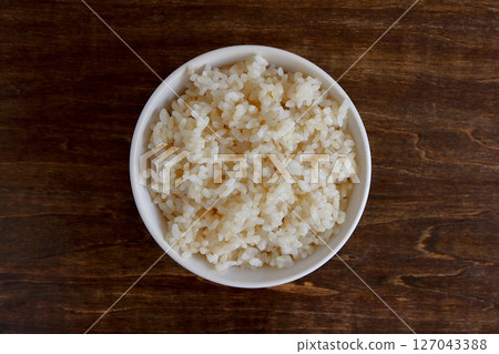 糙米盛在桌子背景的白色碗裡，從上方看 127043388