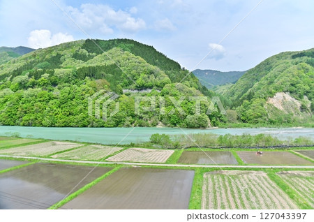 Rice fields after rice planting and the color of the water surface of the Himekawa Second Dam reservoir 127043397