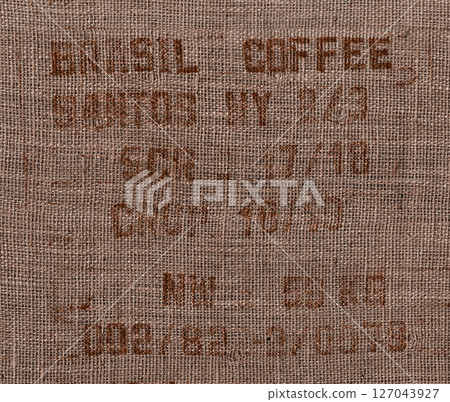 A burlap sack from a coffee plantation with a stamp and inspection holes. A burlap sack from a coffee plantation with a stamp and inspection holes. 127043927
