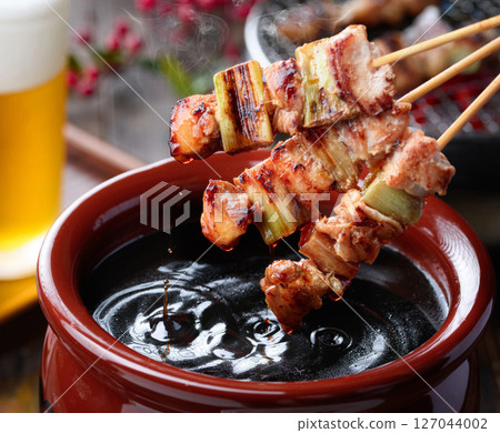 Dip the yakitori in the secret sauce 127044002
