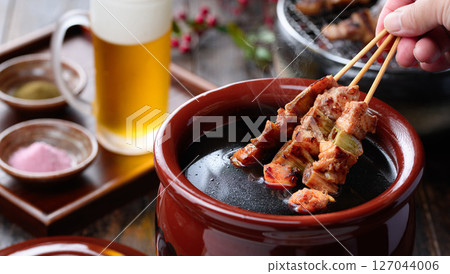A sizzling Japanese-style cut of yakitori dipped in a secret sauce pot 127044006