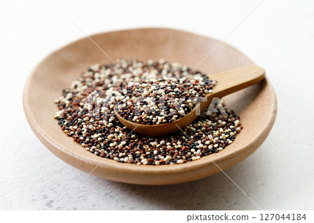 Mix of white, black and red quinoa seeds in wooden spoon. Mix of white, black and red quinoa seeds in wooden spoon. 127044184