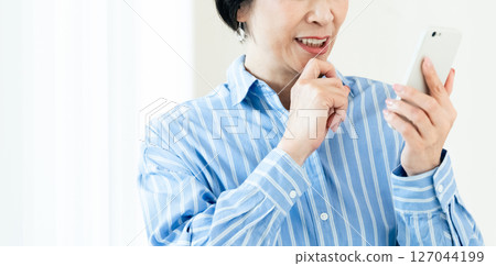 一位操作智能手機的中年婦女 127044199