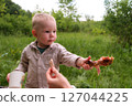 Happy toddler excited about grilled chicken at picnic 127044225