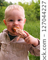 Happy toddler excited about grilled chicken at picnic 127044227