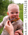 Happy toddler excited about grilled chicken at picnic 127044228