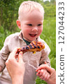 Happy toddler excited about grilled chicken at picnic 127044233
