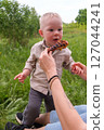 Happy toddler excited about grilled chicken at picnic 127044241