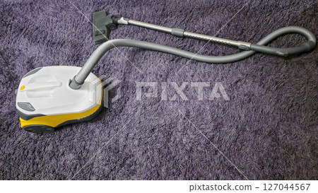Vacuum cleaner on a lilac carpet after cleaning the room. wet cleaning. Vacuum cleaner on a lilac carpet after cleaning the room. wet cleaning. 127044567