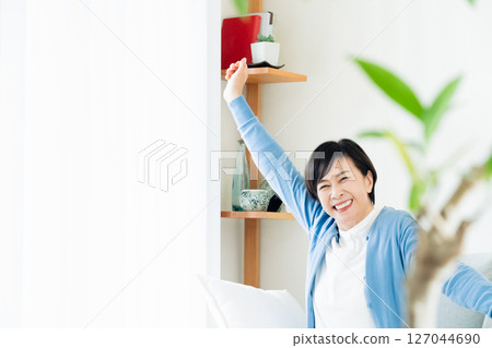 Middle-aged woman relaxing in the living room Middle-aged woman relaxing in the living room 127044690