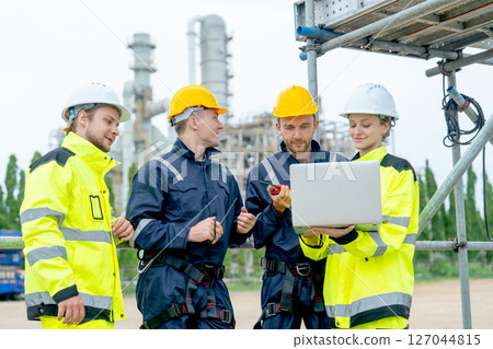 Group of petrochemical workers or technicians work together with one hold laptop and they stand in front the factory. Group of petrochemical workers or technicians work together with one hold laptop and they stand in front the factory. 127044815