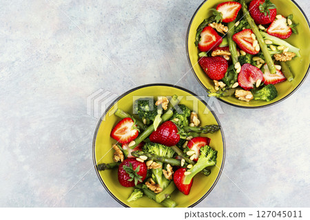 Green mixed salad with green asparagus and strawberries. 127045011