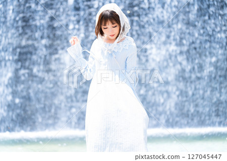 A woman in classical lolita fashion standing in front of a waterfall 127045447