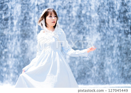 一位身著古典洛麗塔服裝的女性站在瀑布前 127045449
