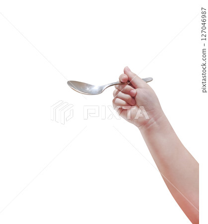 Spoon in child's hand, isolated on white background. 127046987