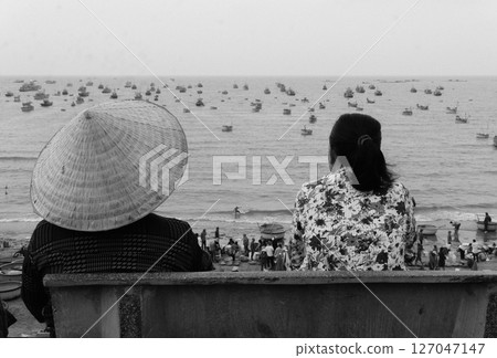 woman in hat sitting on the edge of the sea 127047147