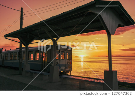 Title (Japanese) A local train bathed in the setting sun and the light sinking into the sea Title (English) Local Train 127047362