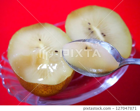 A photo of kiwi fruit being scooped up with a spoon from the right A photo of kiwi fruit being scooped up with a spoon from the right 127047871
