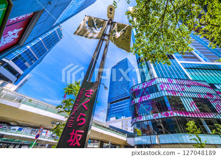 Tokyo cityscape, Japan, June 7th, in front of Shibuya Station. View of the green Sakurazaka Hill and Shibuya Scramble Square. 127048189