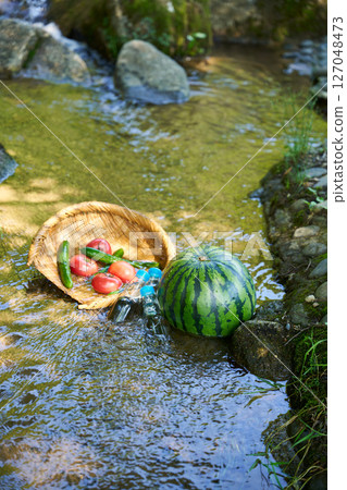 Watermelon and summer vegetables cooled in stream water 127048473