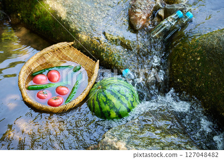 Cooling watermelon and summer vegetables with stream water Cooling watermelon and summer vegetables with stream water 127048482