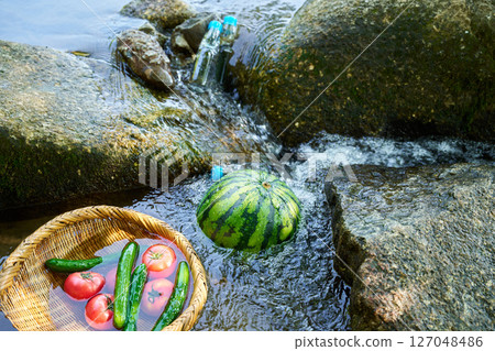Watermelon and summer vegetables cooled in stream water Watermelon and summer vegetables cooled in stream water 127048486