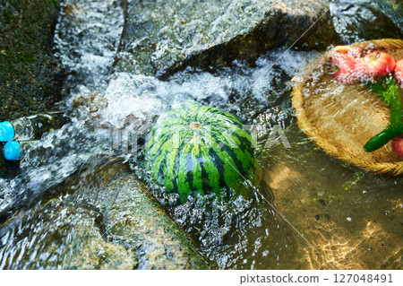 Watermelon and summer vegetables cooled in stream water 127048491