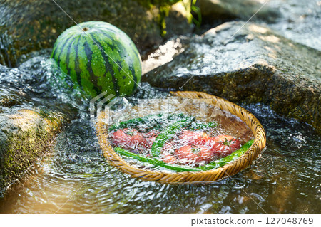 Cooling watermelon and summer vegetables with stream water Cooling watermelon and summer vegetables with stream water 127048769