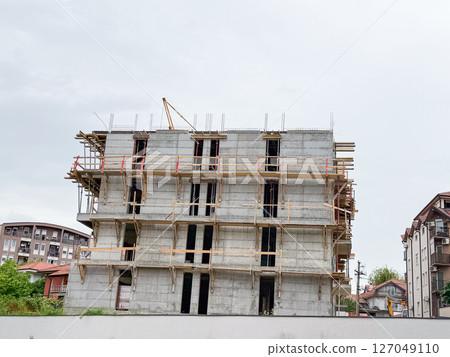 Concrete structure under construction. Urban development, civil engineering, and residential expansion in modern neighborhoods Concrete structure under construction. Urban development, civil engineering, and residential expansion in modern neighborhoods 127049110