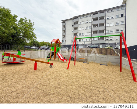 Playground with colorful equipment. Childhood recreation, outdoor activity, and public space design for urban families 127049111
