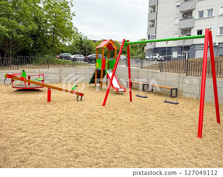 Modern playground in residential area. Childhood activity, outdoor recreation, and safe play environment in urban neighborhoods. 127049112