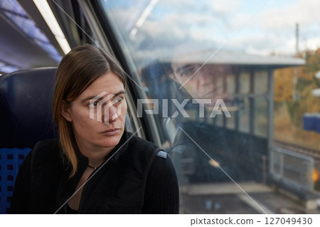 Woman on a train staring out he window 127049430