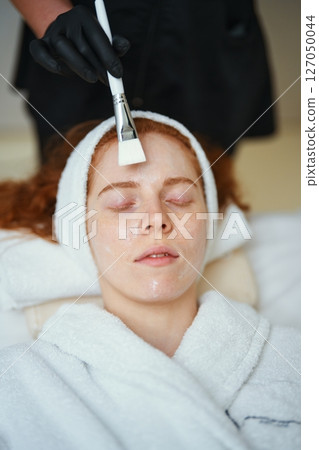 Woman receiving facial treatment at spa in the afternoon 127050044