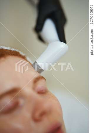 Facial treatment performed using advanced skincare technology in a clinic Facial treatment performed using advanced skincare technology in a clinic 127050045