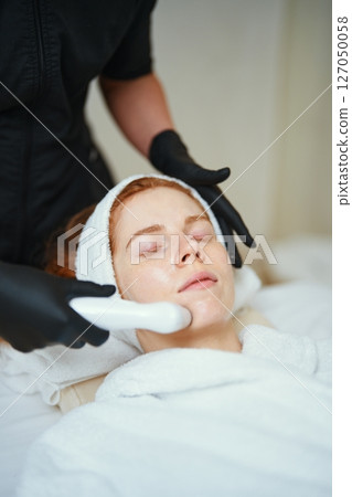 Woman receiving a facial treatment at a spa in a serene atmosphere 127050058