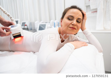 Woman receiving skin treatment in a tranquil spa environment during the day 127050131