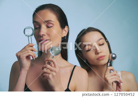 Women enjoying skincare routine with facial tools in tranquil setting Women enjoying skincare routine with facial tools in tranquil setting 127050452