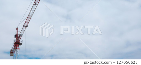 The crane works against the blue sky. Construction, investment, real estate sale 127050623