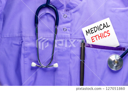 Medical ethics symbol. Concept words Medical ethics on beautiful white card. Stethoscope and pen. Beautiful medical uniform. Healthy lifestyle medical ethics concept. 127051860