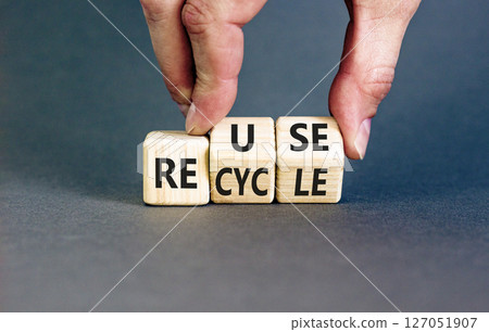 Reuse or recycle symbol. Concept words Reuse Recycle on wooden block. Beautiful grey table grey background. Businessman hand. Business reuse or recycle concept. Copy space. 127051907