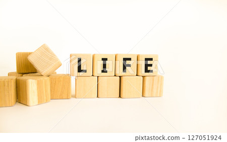 Life symbol. Concept word Life on beautiful wooden blocks. Beautiful white table white background. Business, lifestyle, support and life concept. Copy space. Life symbol. Concept word Life on beautiful wooden blocks. Beautiful white table white background. Business, lifestyle, support and life concept. Copy space. 127051924