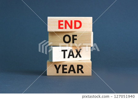 End of tax year symbol. Concept words phrase End of tax year on beautiful wooden blocks. Beautiful grey paper background. Business End of tax year concept. Copy space. 127051940