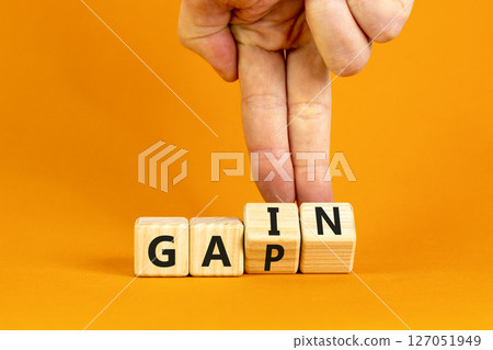 Gain or gap symbol. Concept words Gain Gap on wooden block. Beautiful orange table orange background. Businessman hand. Business gain or gap concept. Copy space. 127051949