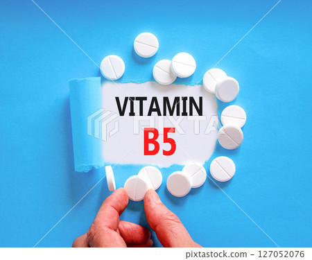 Vitamin B5 pantothenic acid symbol. Concept words Vitamin B5 on beautiful white paper. White pills tablets. Doctor's hand. Beautiful blue background. Medical healthy lifestyle Vitamin B5 concept. 127052076