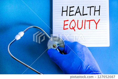 Health equity symbol. Concept words Health equity on beautiful white note. Doctor's hand in blue medical glove. Stethoscope. Beautiful blue background. Medical healthy lifestyle health equity concept 127052087