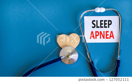 Sleep apnea symbol. Concept words Sleep apnea on beautiful white card. Wooden heart and stethoscope. Beautiful blue background. Medical healthy lifestyle sleep apnea concept. 127052111